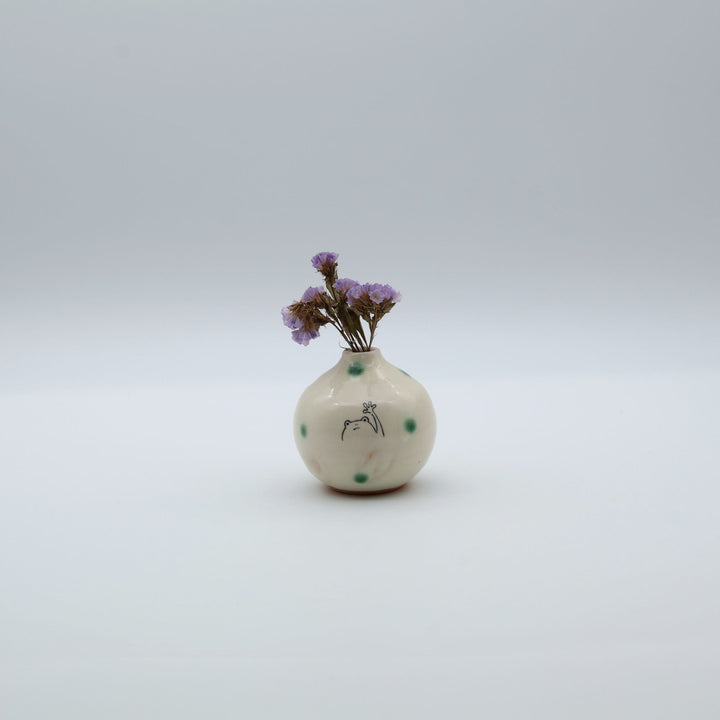 カエルのイラストと緑の織部釉ドットが描かれた、手のひらサイズの丸い萩焼楓窯の花入れ