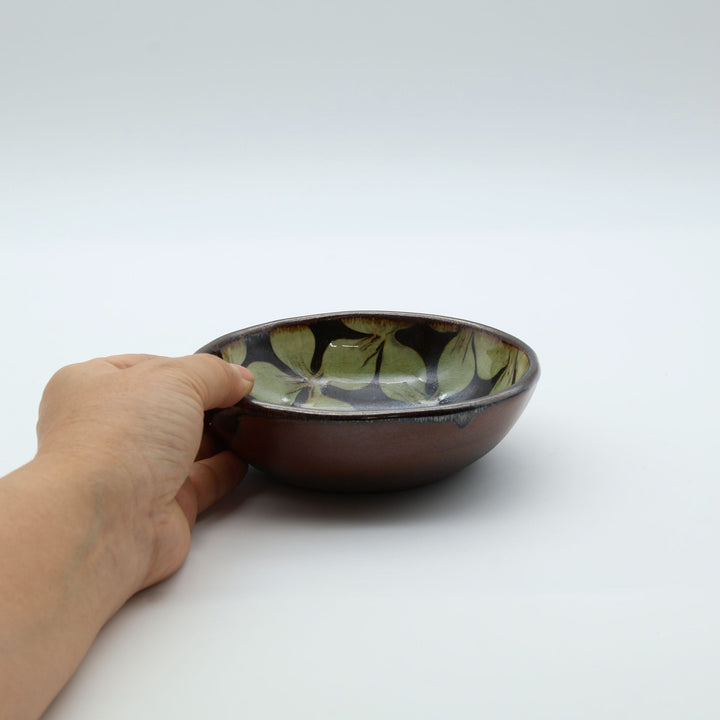 宮崎県生楽陶苑のスリップウェア。外側は素朴な茶系の陶器肌、内側に緑の花柄紋様が見える美しい小鉢。 